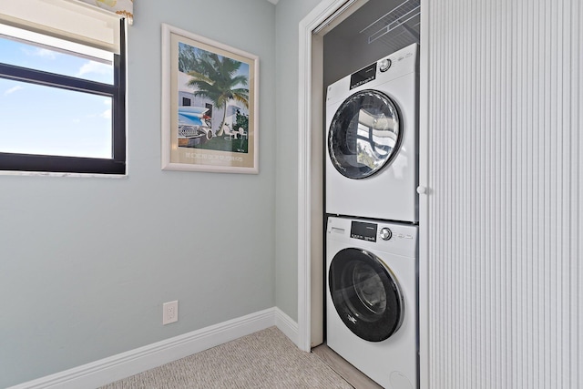 laundry room featuring stacked washer and dryer, laundry area, and baseboards