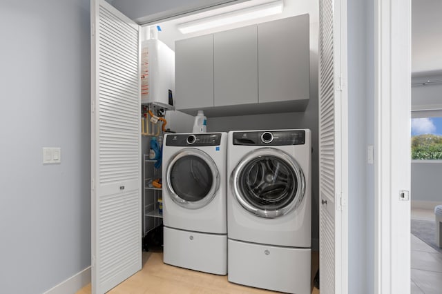 758 N St, West Palm Beach, FL 33401 - laundry room featuring cabinet space, water heater, washing machine and dryer, and baseboards