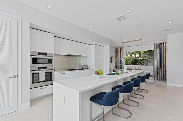 758 N St, West Palm Beach, FL 33401 - kitchen with modern cabinets, a sink, gas cooktop, stainless steel double oven, and white cabinetry
