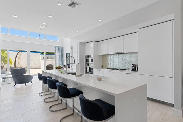758 N St, West Palm Beach, FL 33401 - kitchen with modern cabinets, a sink, stainless steel double oven, white cabinetry, and light tile patterned flooring
