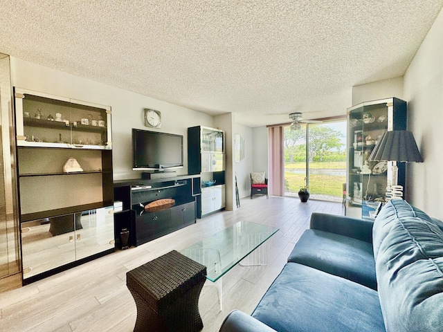 7145 Huntington Ln Unit 102, Delray Beach, FL 33446 - living area featuring light wood-type flooring, ceiling fan, and a textured ceiling
