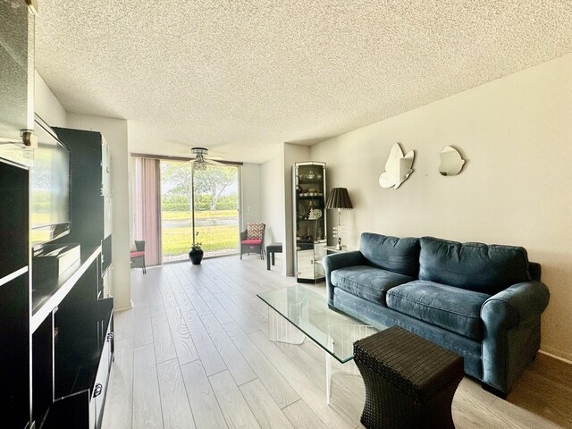7145 Huntington Ln Unit 102, Delray Beach, FL 33446 - living room with a textured ceiling, wood finished floors, and a ceiling fan