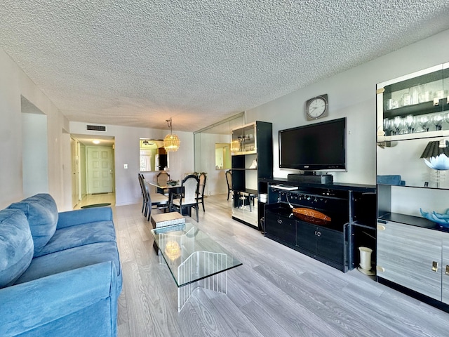 7145 Huntington Ln Unit 102, Delray Beach, FL 33446 - living area featuring a textured ceiling, visible vents, and wood finished floors