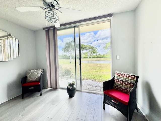 7145 Huntington Ln Unit 102, Delray Beach, FL 33446 - sitting room with a wall of windows, a water view, wood finished floors, and a healthy amount of sunlight