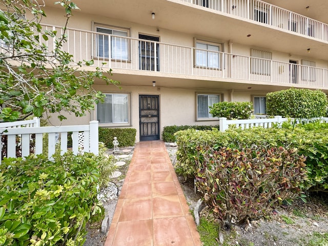 7145 Huntington Ln Unit 102, Delray Beach, FL 33446 - property entrance with stucco siding and fence