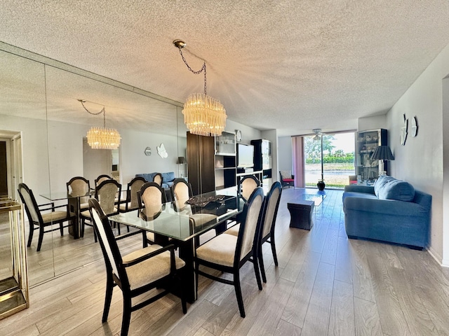 7145 Huntington Ln Unit 102, Delray Beach, FL 33446 - dining room with baseboards, a notable chandelier, light wood-style flooring, and a textured ceiling