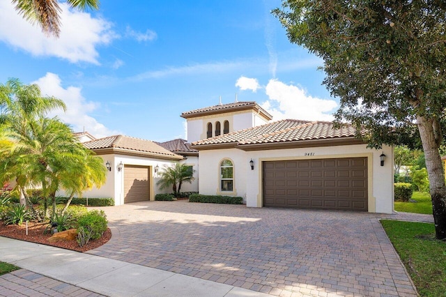 9481 Mcaneeny Ct, Wellington, FL 33414 - mediterranean / spanish-style home with a garage, stucco siding, and decorative driveway