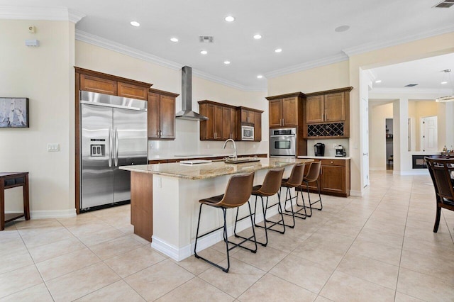 9481 Mcaneeny Ct, Wellington, FL 33414 - kitchen with built in appliances, wall chimney range hood, an island with sink, recessed lighting, and light tile patterned flooring