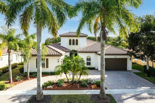 9481 Mcaneeny Ct, Wellington, FL 33414 - mediterranean / spanish home with stucco siding, a garage, decorative driveway, and a tiled roof