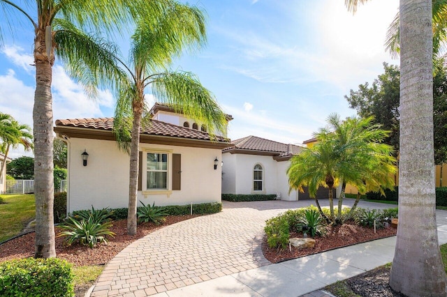 9481 Mcaneeny Ct, Wellington, FL 33414 - mediterranean / spanish house featuring curved driveway, stucco siding, a tile roof, and fence