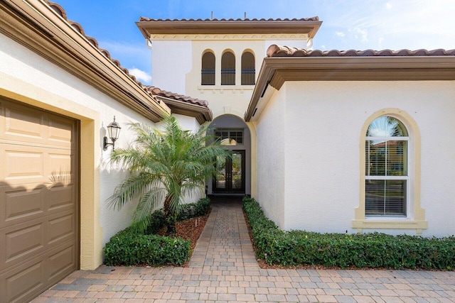 9481 Mcaneeny Ct, Wellington, FL 33414 - doorway to property with stucco siding, a tiled roof, and an attached garage