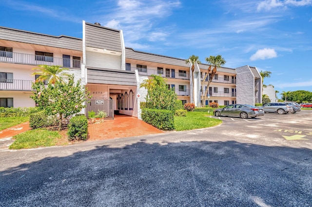 view of apartment building / complex featuring uncovered parking