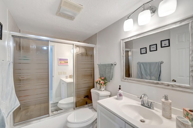 full bath with toilet, a shower with shower door, vanity, and a textured ceiling
