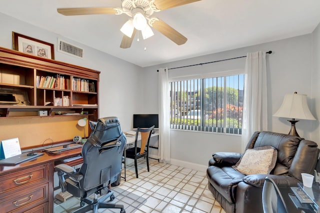office space featuring a ceiling fan, baseboards, and light floors