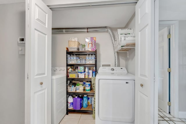 laundry room featuring light tile patterned floors and washer and clothes dryer