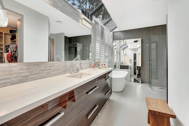 2393 NW 59th St, Boca Raton, FL 33496 - bathroom with a walk in closet, a freestanding bath, a shower stall, tasteful backsplash, and vanity
