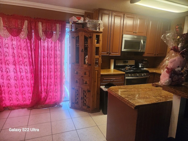 1441 W Central St, Lantana, FL 33462 - kitchen featuring stainless steel appliances, light tile patterned flooring, and ornamental molding