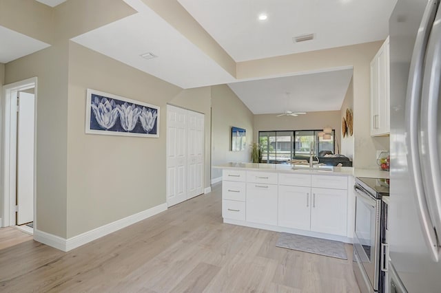 kitchen with freestanding refrigerator, light wood-style floors, white cabinetry, and electric stove