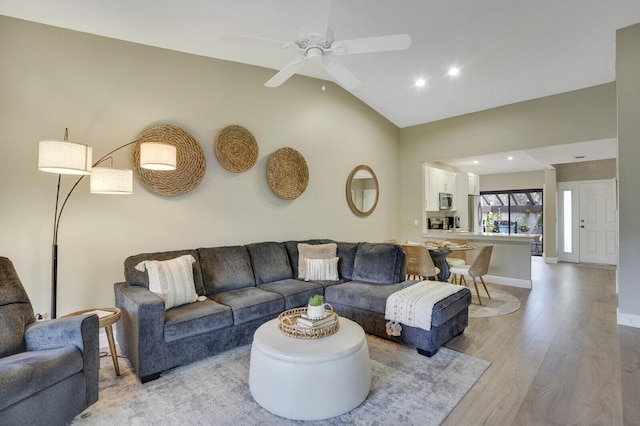 living area with recessed lighting, vaulted ceiling, light wood-style flooring, a ceiling fan, and baseboards