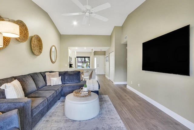 living room featuring recessed lighting, baseboards, ceiling fan, vaulted ceiling, and wood finished floors