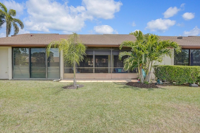 back of property featuring a lawn and a sunroom
