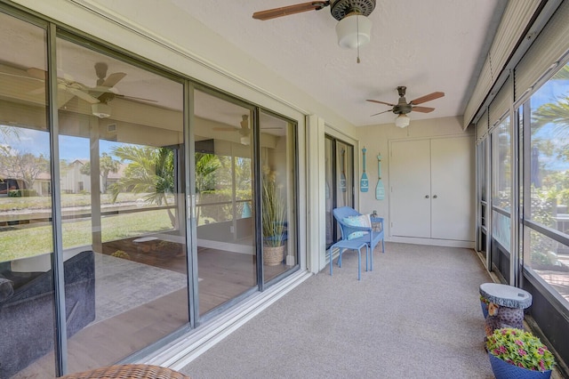unfurnished sunroom featuring a ceiling fan and a healthy amount of sunlight