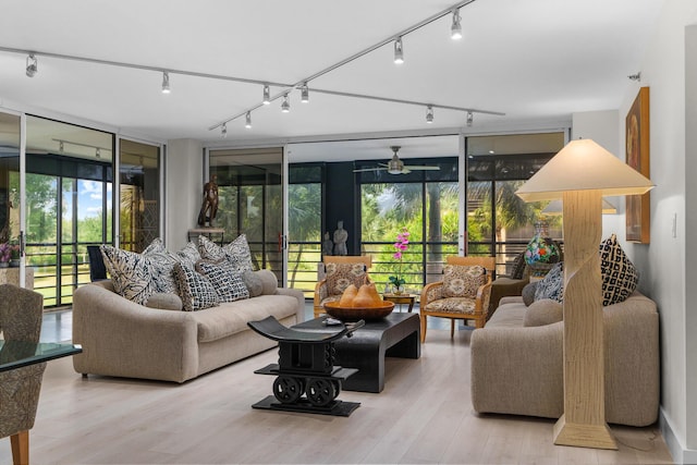 living area featuring track lighting, floor to ceiling windows, wood finished floors, and ceiling fan