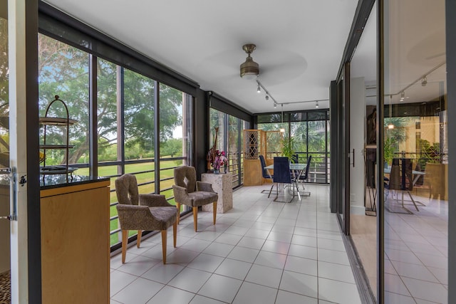 sunroom featuring track lighting and tile patterned floors