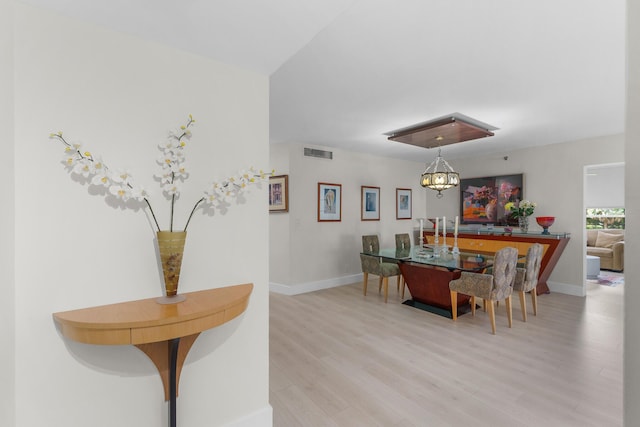 dining space featuring light wood-style flooring and baseboards