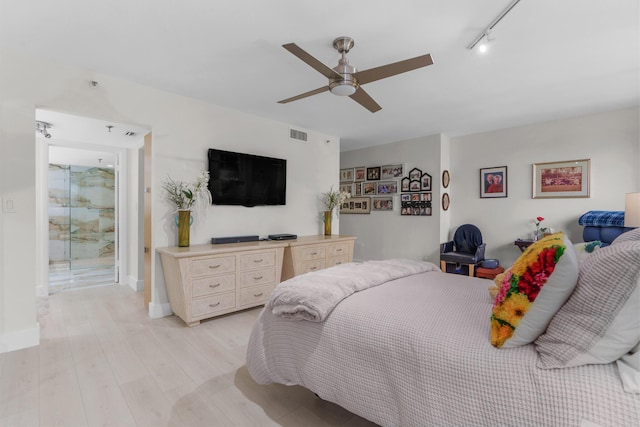 bedroom with track lighting, light wood-style flooring, ceiling fan, and baseboards