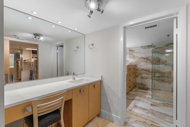 full bath featuring a marble finish shower, recessed lighting, a walk in closet, vanity, and marble finish floors