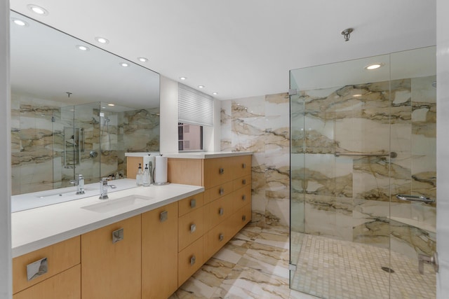 full bath featuring a marble finish shower, vanity, marble tiled flooring, tile walls, and recessed lighting