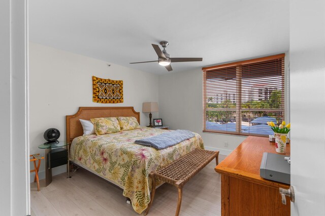 bedroom featuring light wood-style floors, baseboards, and ceiling fan