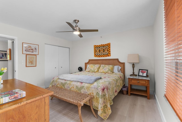 bedroom featuring light wood-style floors, a closet, ceiling fan, and baseboards