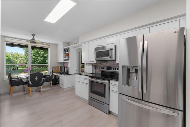 kitchen with stainless steel appliances, dark countertops, white cabinetry, backsplash, and open shelves