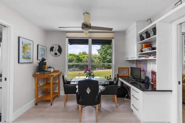 office with a ceiling fan, light wood-style flooring, built in study area, and baseboards