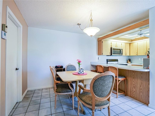 dining space with light tile patterned floors, baseboards, and a ceiling fan