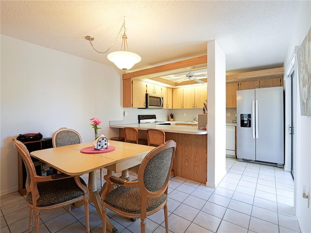 dining space with light tile patterned floors, ceiling fan, and a textured ceiling