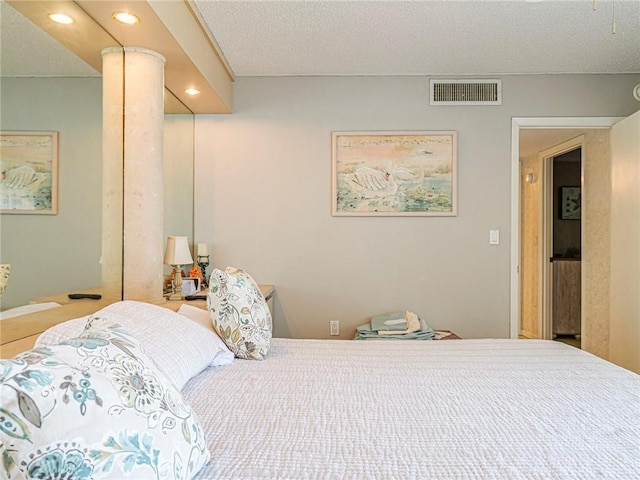 bedroom with a textured ceiling, visible vents, and recessed lighting