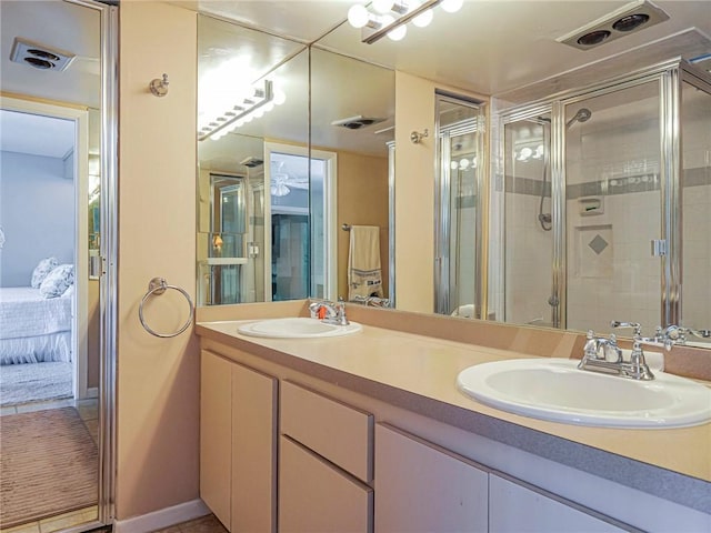 ensuite bathroom with a sink, double vanity, connected bathroom, and a shower stall