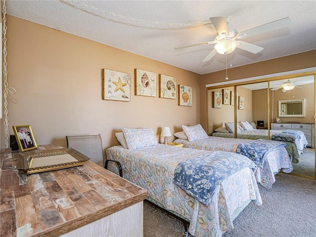 carpeted bedroom with a closet, a textured ceiling, and a ceiling fan