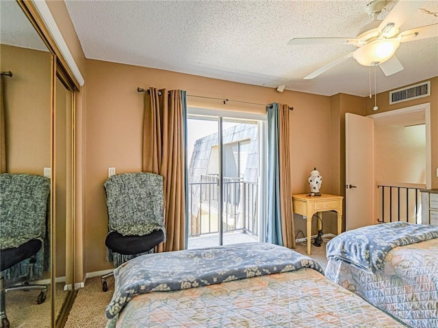 bedroom featuring a closet, carpet floors, a textured ceiling, visible vents, and access to outside