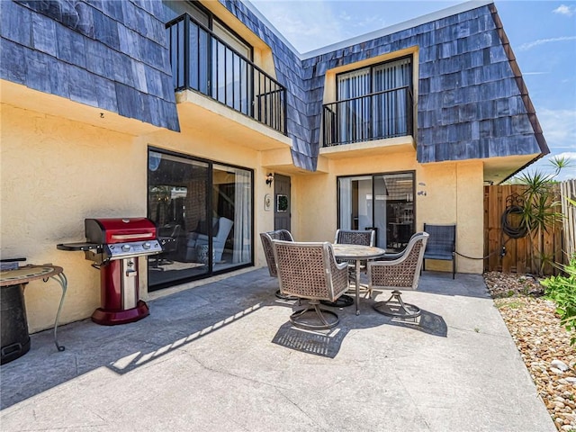 view of patio / terrace featuring a balcony, outdoor dining space, grilling area, and fence