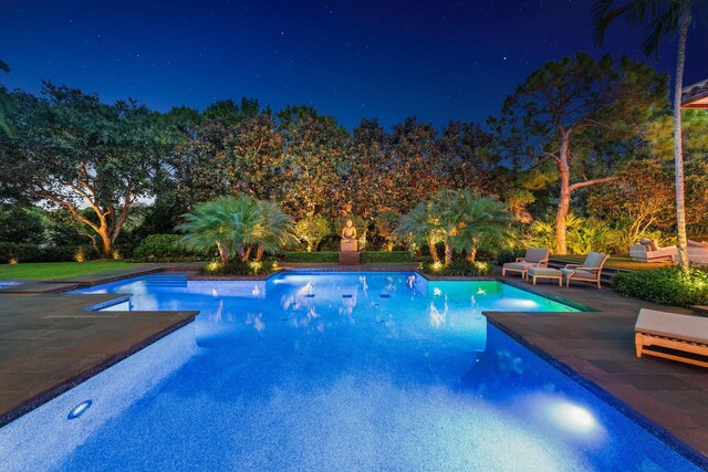 232 Bears Club Dr, Jupiter, FL 33477 - pool at night featuring a patio and an outdoor pool