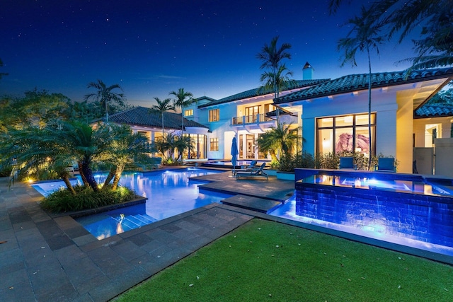 232 Bears Club Dr, Jupiter, FL 33477 - pool at night with a jacuzzi, an outdoor pool, and a patio