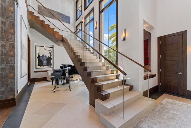 232 Bears Club Dr, Jupiter, FL 33477 - stairway featuring baseboards and a high ceiling
