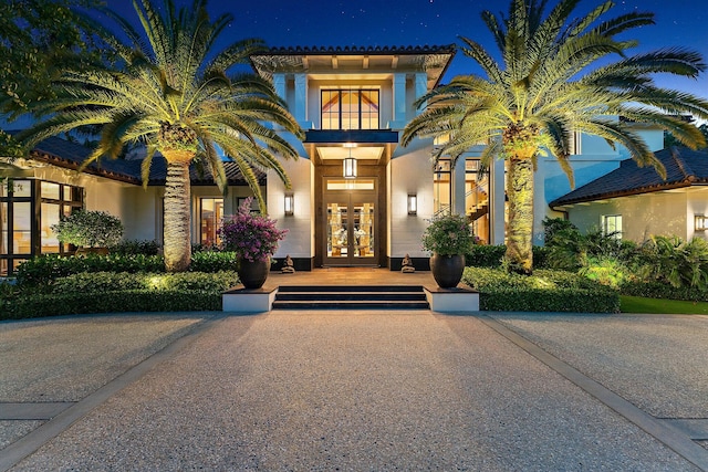 232 Bears Club Dr, Jupiter, FL 33477 - exterior entry at night with french doors