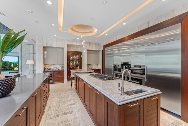 232 Bears Club Dr, Jupiter, FL 33477 - kitchen with a sink, stainless steel appliances, a large island, backsplash, and modern cabinets