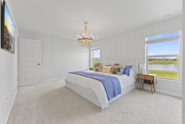 4235 Troon Pl, Fort Pierce, FL 34947 - bedroom with a water view, carpet floors, a chandelier, and baseboards