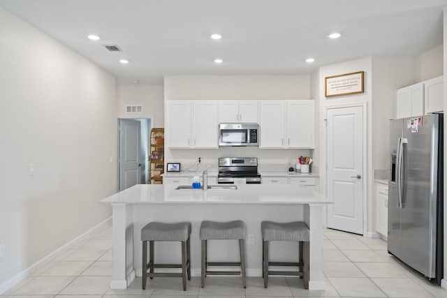 4235 Troon Pl, Fort Pierce, FL 34947 - kitchen featuring appliances with stainless steel finishes, a sink, a breakfast bar, white cabinets, and recessed lighting